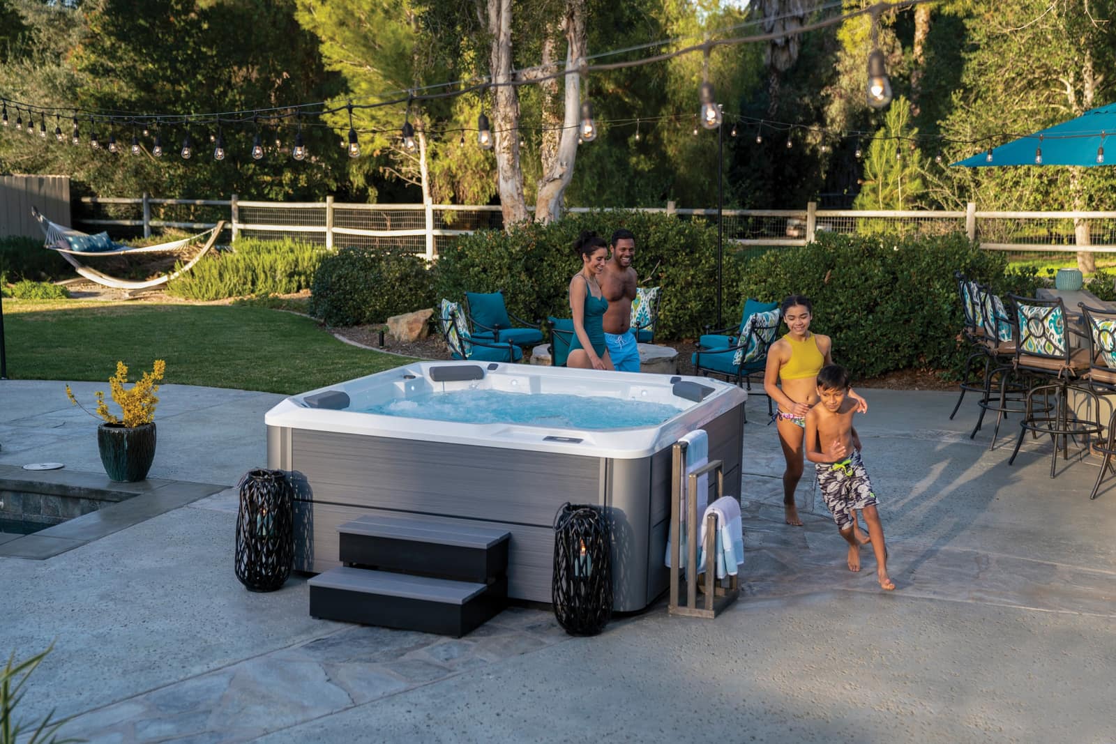Family gathering around a Hot Spot Relay hot tub in the backyard